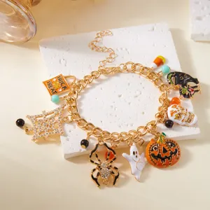 Vista de detalle de pulsera Halloween dorada con dijes de calabaza y pequeño fantasma