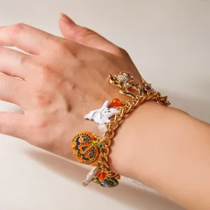 Vista detallada de la pulsera de Halloween con colgantes de calabaza y fantasma en la muñeca