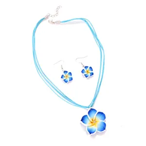 Nahaufnahme des blau verlaufenden Plumeria-Schmucksets mit Halskette und Ohrringen