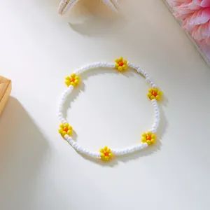 Handgemaakte Boheemse enkelband van witte kralen met gele bloemen voor een zomerse stijl