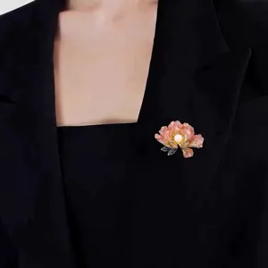 Detail showing an elegant pink peony flower brooch pinned on a black blazer jacket