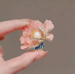 Detail view of a Chinese style pink peony flower brooch with pearl center and crystals