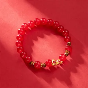 Close-up of a festive red beaded bracelet featuring golden snake charms for the 2025 Lunar New Year