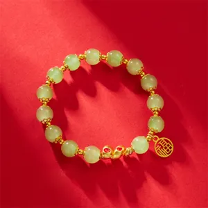Close-up of the 2025 Year of the Snake zodiac bracelet with green beads and gold pendant
