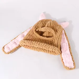 Close-up detail of chunky knit brown ski mask with pink bunny ears and face opening.