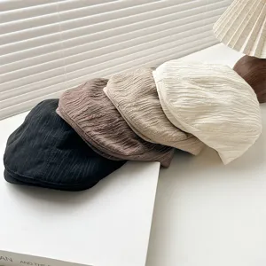 Close-up details of retro pleated flat caps in multiple colors, stylish casual autumn wear.