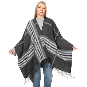 Vista completa del elegante poncho de punto para mujer con cuadros grises y flecos