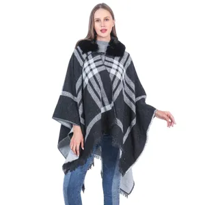 Detalle de capa poncho de cuadros para mujer con cuello de piel sintética y flecos