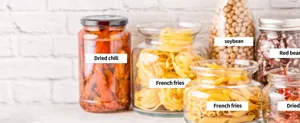 Close-up view of clear glass storage jars filled with various dried goods and pasta.