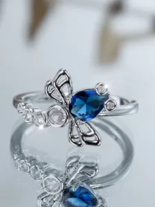 Primo piano di un anello libellula vintage con zircone blu a goccia e pietre bianche