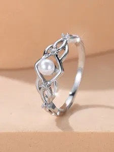 Nahaufnahme eines silbernen Rings mit gedrehtem Design, Kunstperle und feinem Zirkonia
