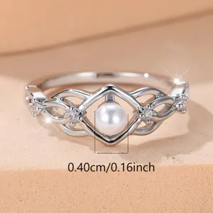 Eleganter silberner Ring mit Perlenzentrum, gewundenem Hohlraumdesign und funkelnden Steinen