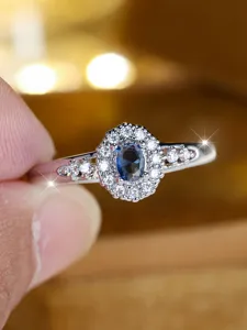 Nahaufnahme eines luxuriösen ovalen blauen Zirkonrings mit Doppel-Halo und Hohlband
