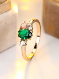 Detailed close-up shot of a golden ring featuring a green oval stone and opal accent