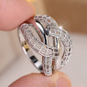 Detailed view of an intricate hollow woven crisscross ring with silver-plated finish