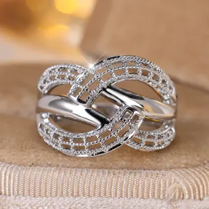 Close-up of minimalist silver hollow woven cross ring showing intricate mesh detail