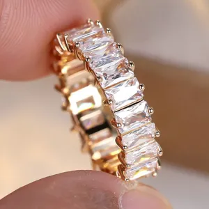 Eleganter vergoldeter Eternity-Ring mit rechteckigen, klaren Zirkonia-Steinen.