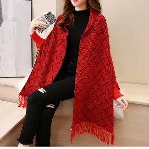 Poncho in maglia rossa con motivi neri e dettagli di frange indossato da una modella