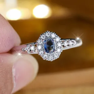Eleganter Ring mit ovalem blauem Zirkonia, doppelter Halo und funkelndem Band.