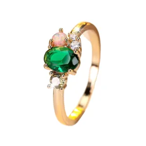 Elegant gold ring featuring a large oval green emerald and pink opal stone inlay