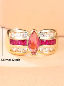 Vista macro detallada de anillo dorado con gema magenta, medida de ancho de 1,1 cm