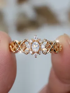 Detailed close-up of a vintage filigree gold-plated ring with oval moonstone and halo