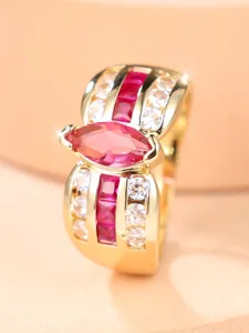 Vista macro de un anillo ancho de oro con una gema rosa marquesa y engaste de pavé