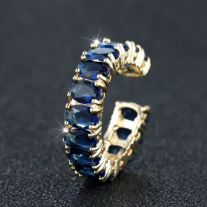 Detailopname van een gouden open ring bezet met ovale blauwe zirkonia-stenen