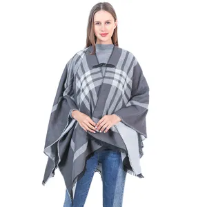 Vista detallada del poncho de cuadros grises para mujer con hebilla de cuero y flecos.