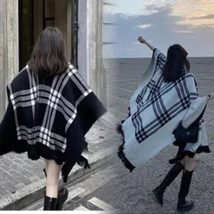 Vista trasera de mujeres con ponchos de punto a cuadros gruesos y elegantes con flecos
