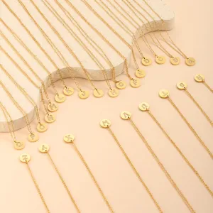 Detailansicht von 26 goldenen Titanstahl-Halsketten mit funkelnden Initialanhängern.