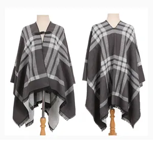 Vista frontal y posterior de un poncho chal a cuadros grises con flecos y hebilla para mujer