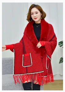 Detalle de un poncho de punto de pata de gallo rojo con cuello de pelo y flecos.