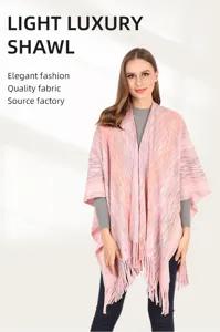 Detailed view of an autumn warm pink knitted poncho shawl with tassels and textured fabric