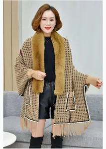 Detalle de un poncho de punto de pata de gallo para mujer con cuello de piel y flecos