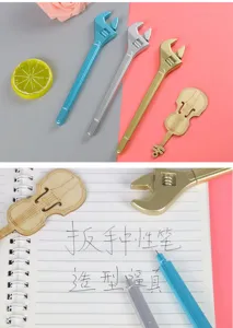 Creative wrench-shaped gel pens in gold, silver and blue color writing on a notebook.