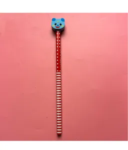 Gros plan d'un crayon rouge à pois surmonté d'une gomme décorative en forme d'ours bleu