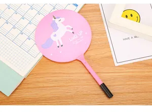 Cute pink unicorn cartoon fan ballpoint pen displayed on a wooden desk lifestyle background