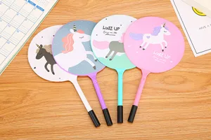 Set of four colorful cartoon unicorn fan-shaped ballpoint pens on a wooden desk surface
