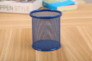 Vista detallada de un portalápices de malla metálica azul sobre un escritorio de madera