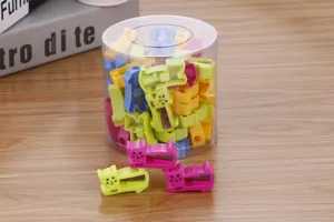 Close-up of cute cat-shaped pencil sharpeners in various candy colors with storage bucket