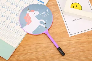 Close-up of a cute purple ballpoint pen featuring a unicorn fan design on a desk