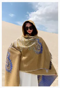 Detailed view of a bohemian hooded knit shawl featuring intricate blue paisley embroidery