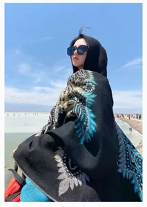 Elegant black hooded imitation cashmere shawl with blue paisley pattern worn at beach