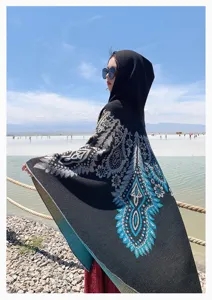 Outdoor view of a bohemian hooded shawl with blue floral pattern at salt lake.