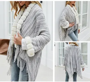Detail view of grey knit shawl featuring plush fur trim and elegant fringe accents.