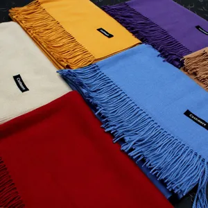 Detailansicht von einfarbigen Pashmina-Schals mit Fransen in verschiedenen Farben.
