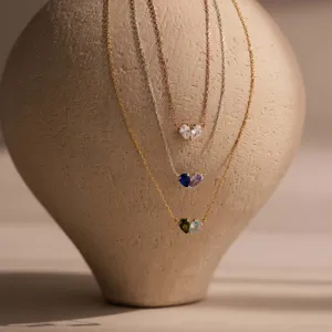 Elegant heart-shaped necklaces featuring pear-cut crystals displayed on a ceramic vase