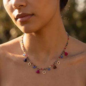 Close-up detail of bohemian style colorful beaded necklace with tassels and flower charms