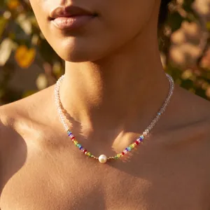 Close-up view of handmade Bohemian rainbow beaded necklace with a central white pearl